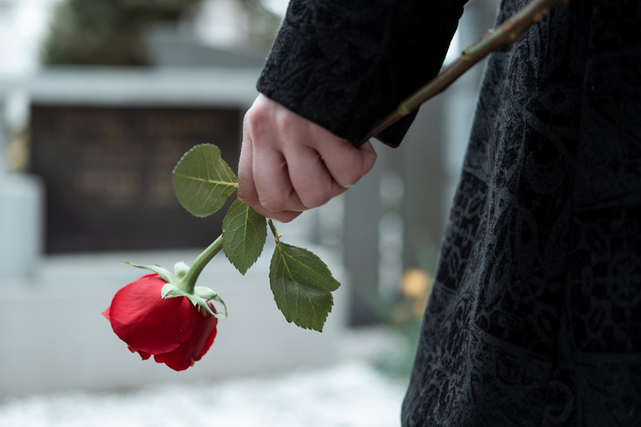 kobieta z czerwoną różą na cmentarzu